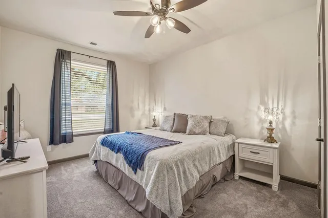 a bedroom with a bed a chandelier and a flat tv