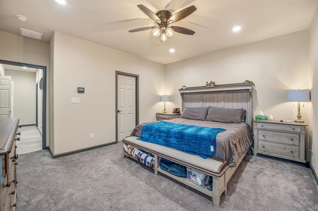 435 Edwards Drive Dublin, TX 76446 - Photo 21 of 40 a bedroom with a bed and a chandelier