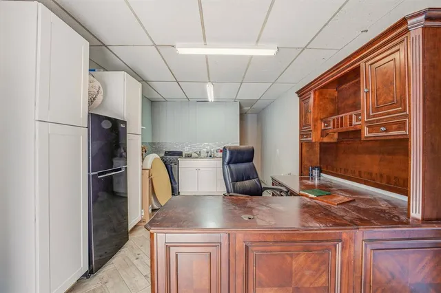 a kitchen with stainless steel appliances kitchen island granite countertop a refrigerator a stove and a sink with wooden floor