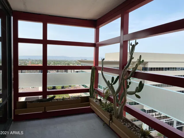 a view of an empty room with wooden floor and furniture