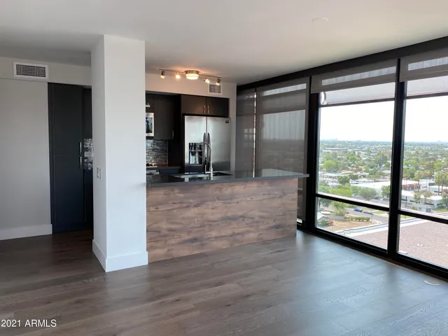 a view of hallway with a large window and wooden floor