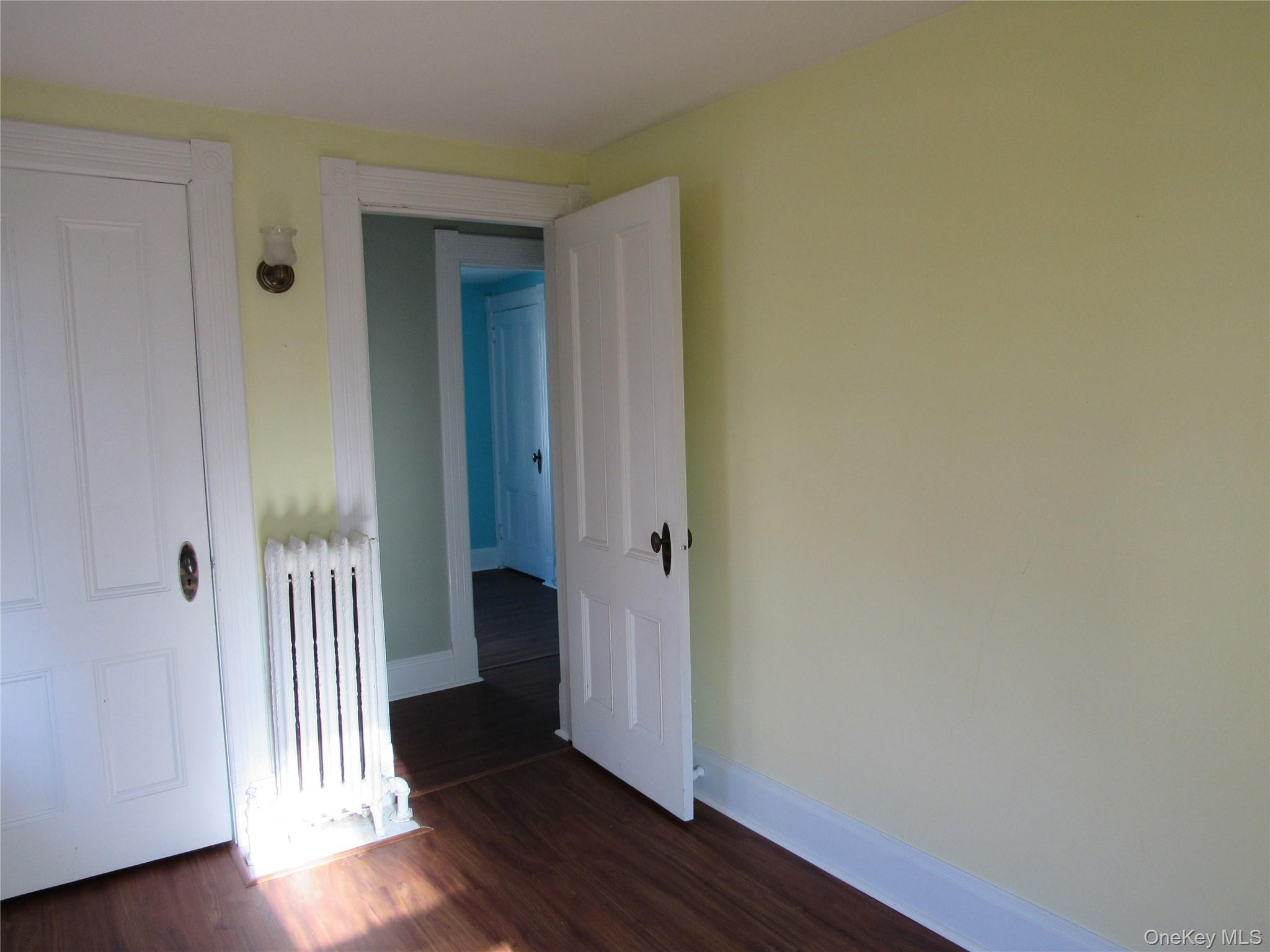98 Main Street Chester, NY 10918 - Photo 25 of 32 Bedroom #4 with radiator heating unit and dark wood-style flooring