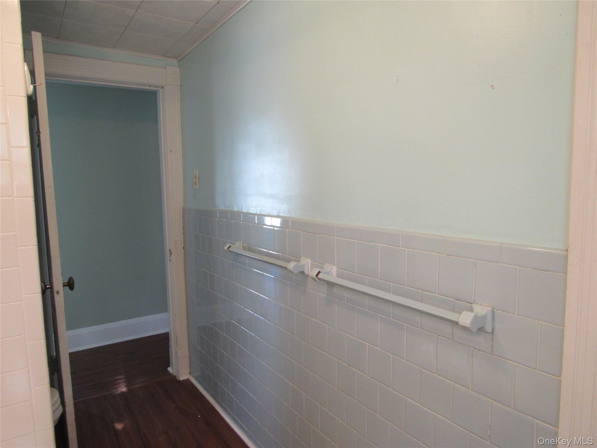 98 Main Street Chester, NY 10918 - Photo 27 of 32 Bathrrom with tile walls, a wainscoted wall, and dark wood-type flooring