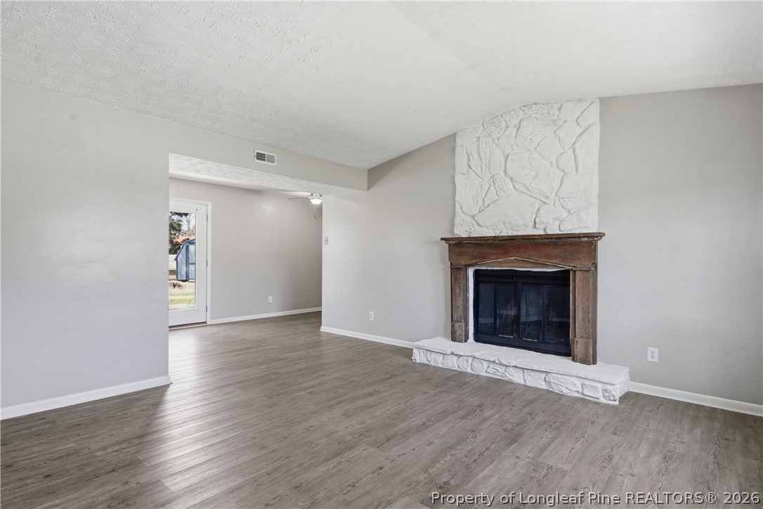 6319 Rustic Ridge Hope Mills, NC 28348 - Photo 5 of 39 a view of an empty room with wooden floor fireplace and a window
