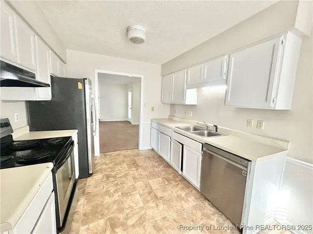 a kitchen with granite countertop a refrigerator and a sink