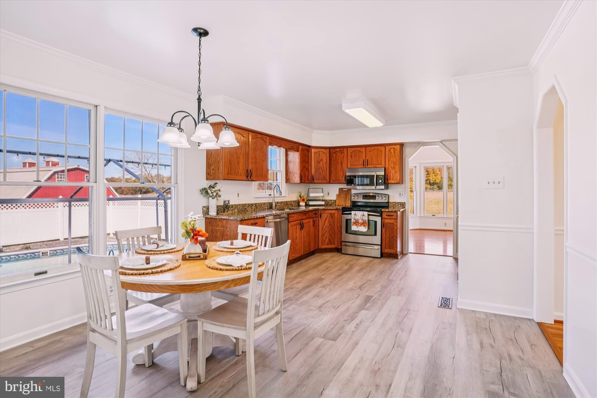 7951 Olivers Shop Road La Plata, MD 20646 - Photo 10 of 32 a kitchen with stainless steel appliances kitchen island granite countertop a refrigerator a stove top oven a sink dishwasher and white cabinets with wooden floor