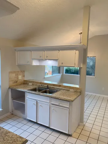 a kitchen with granite countertop a sink and a stove