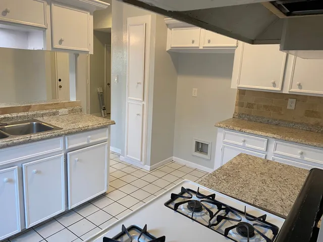 a kitchen with a sink stove and cabinets