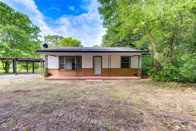 a view of a house with backyard and a tree