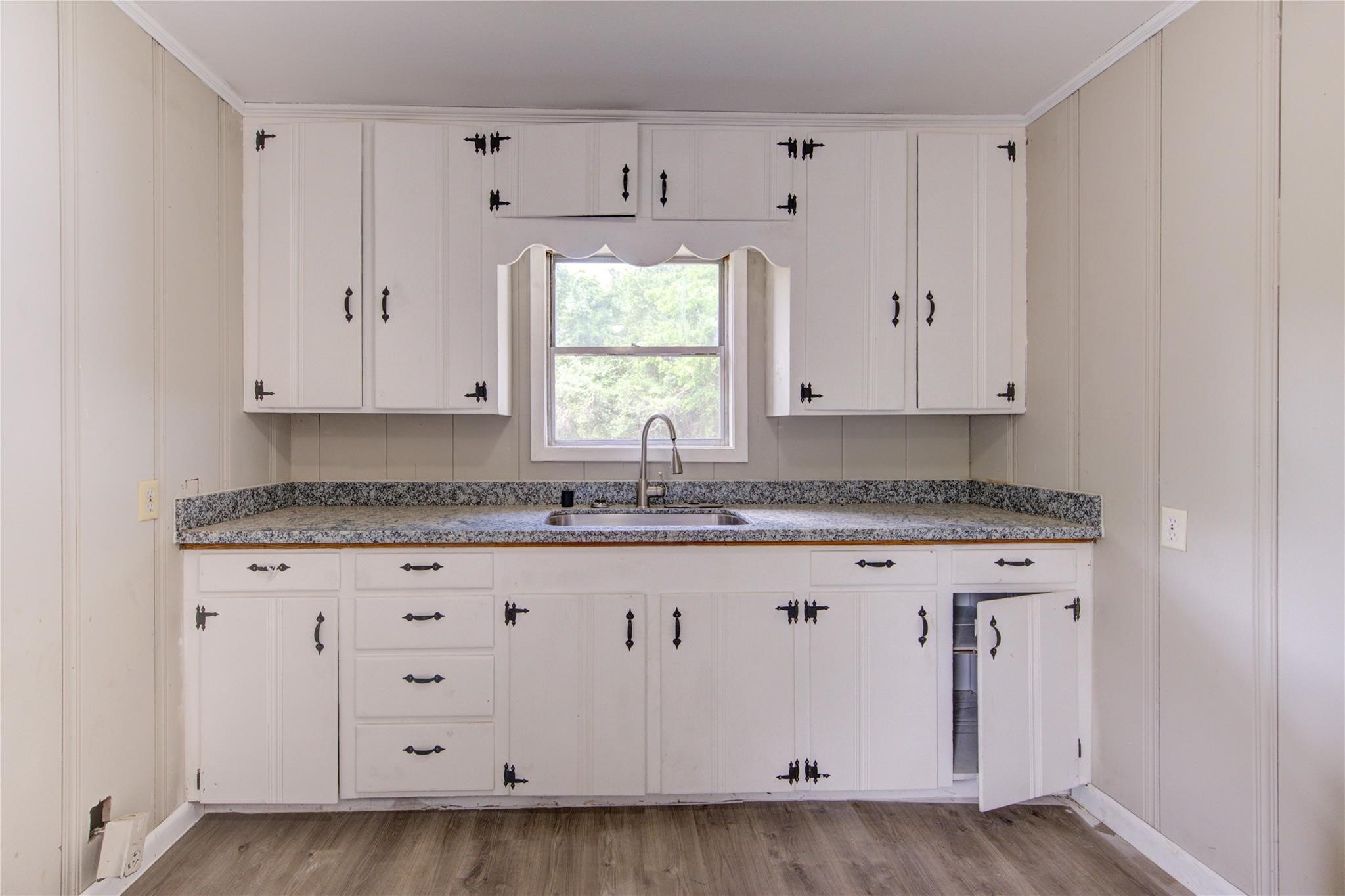 808 State Highway Loop Goodrich, TX 77335 - Photo 22 of 45 a kitchen with granite countertop white cabinets and sink