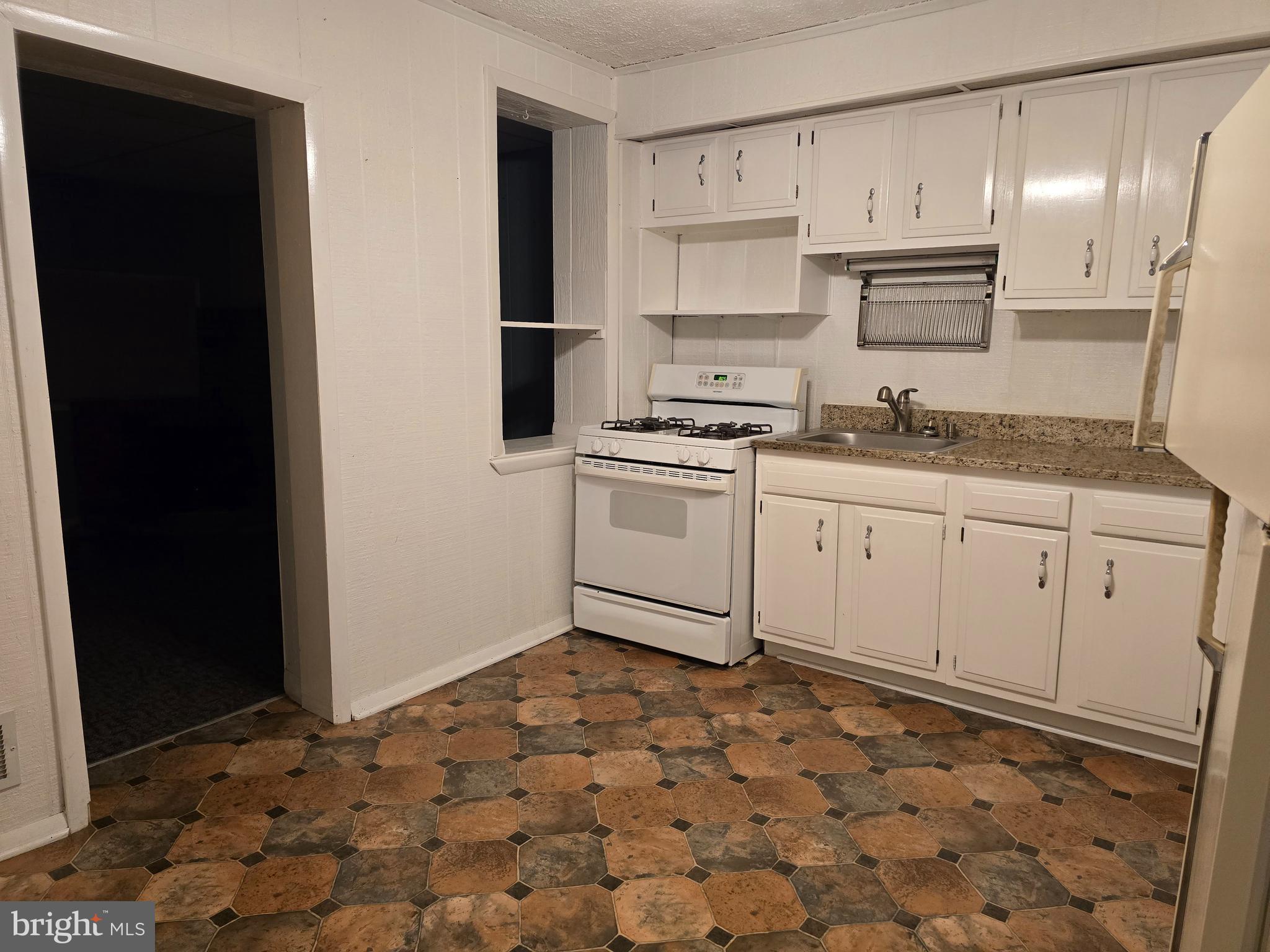 1666 Mussula Road Towson, MD 21286 - Photo 3 of 21 a kitchen with granite countertop a stove a sink and a refrigerator