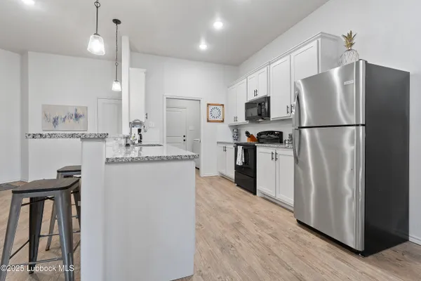 a kitchen with a refrigerator a sink and cabinets