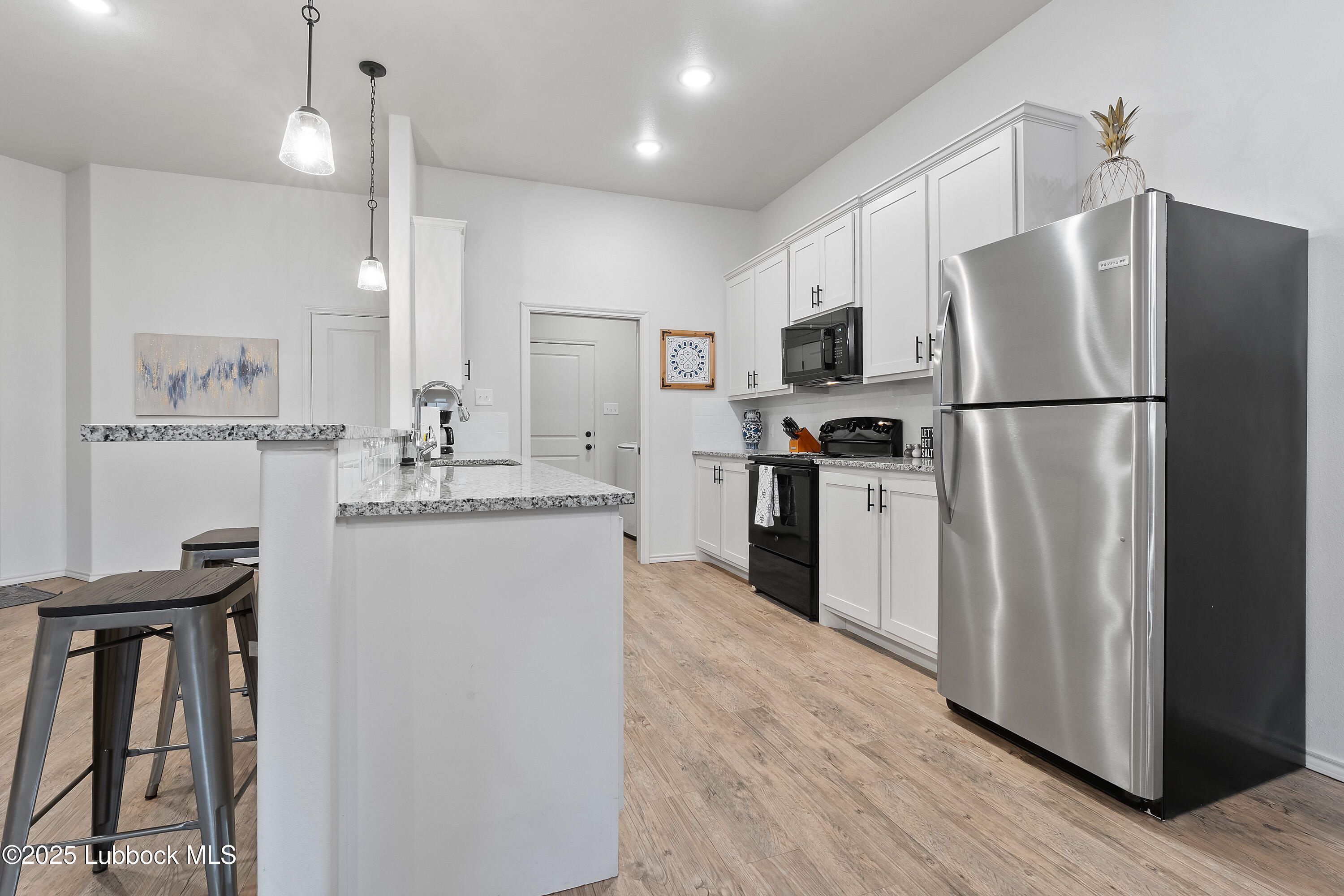 5526 Lehigh Street Lubbock, TX 79416 - Photo 11 of 23 a kitchen with a refrigerator a sink and cabinets