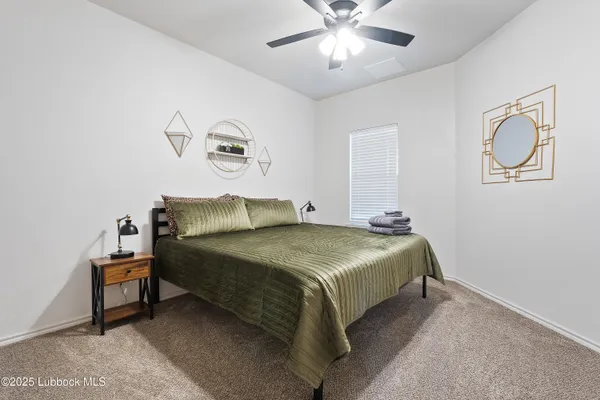 a spacious bedroom with a bed and a chandelier