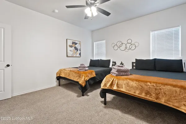 a bedroom with 2 bed and a chandelier