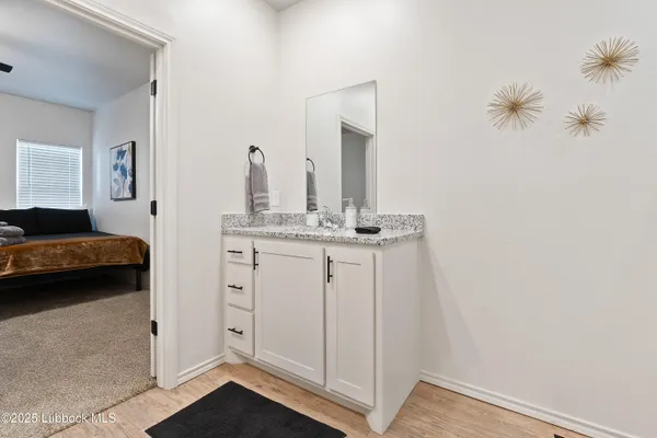 a en suite bathroom with a granite countertop sink and a mirror