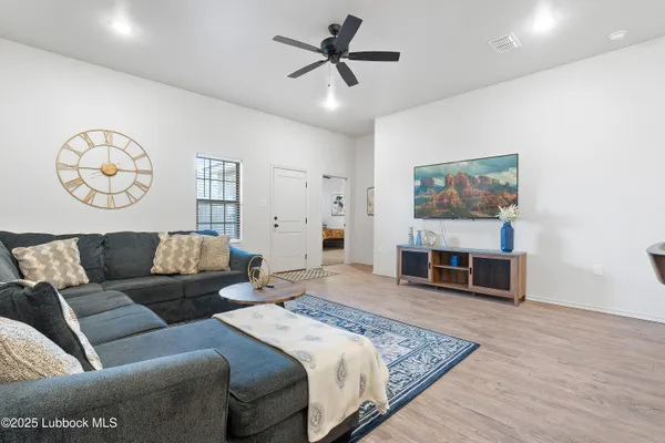 a spacious bedroom with a bed a couch and a chandelier