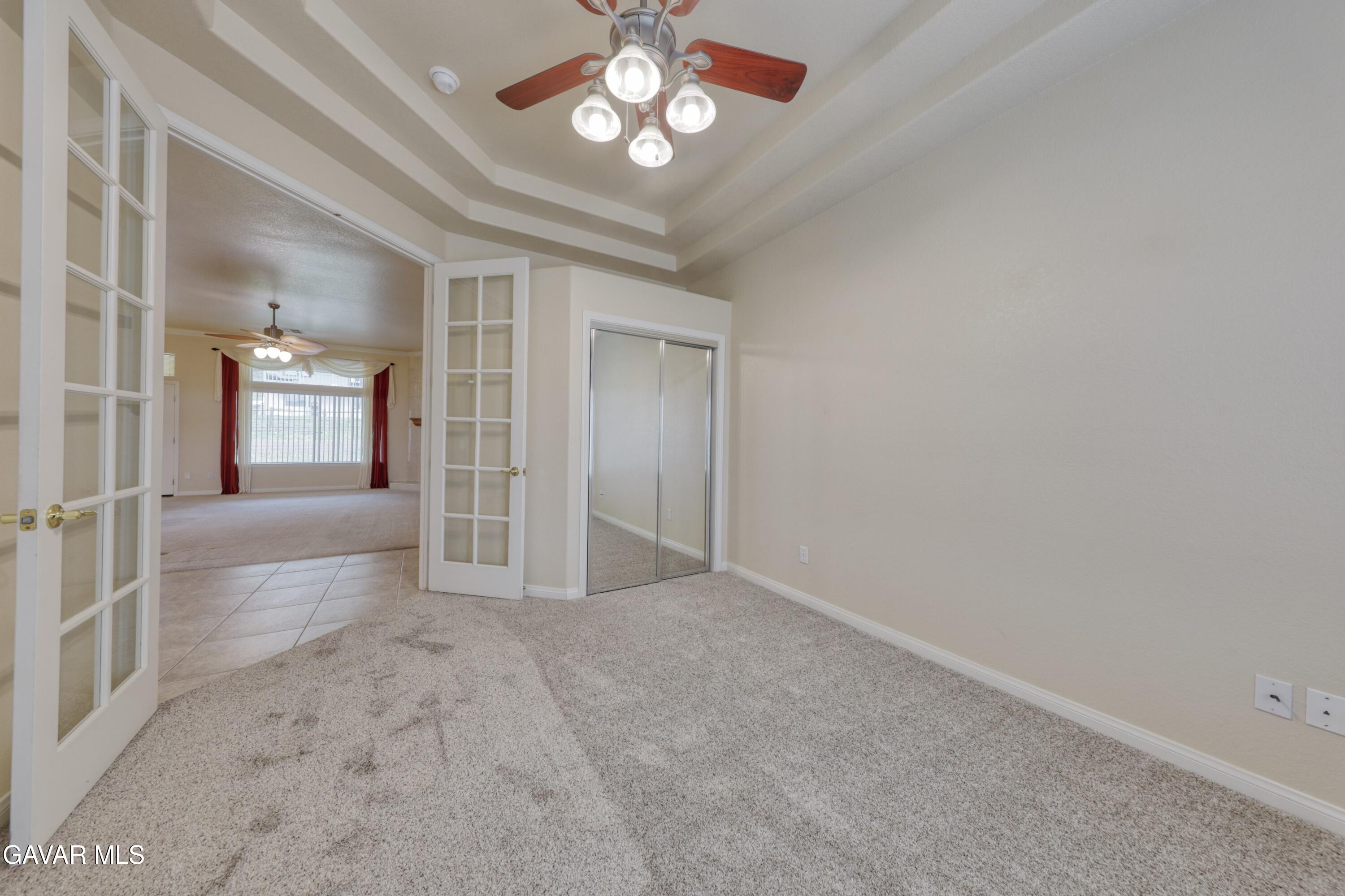23780 Coyote Court Tehachapi, CA 93561 - Photo 17 of 48 en empty room with windows and ceiling fan