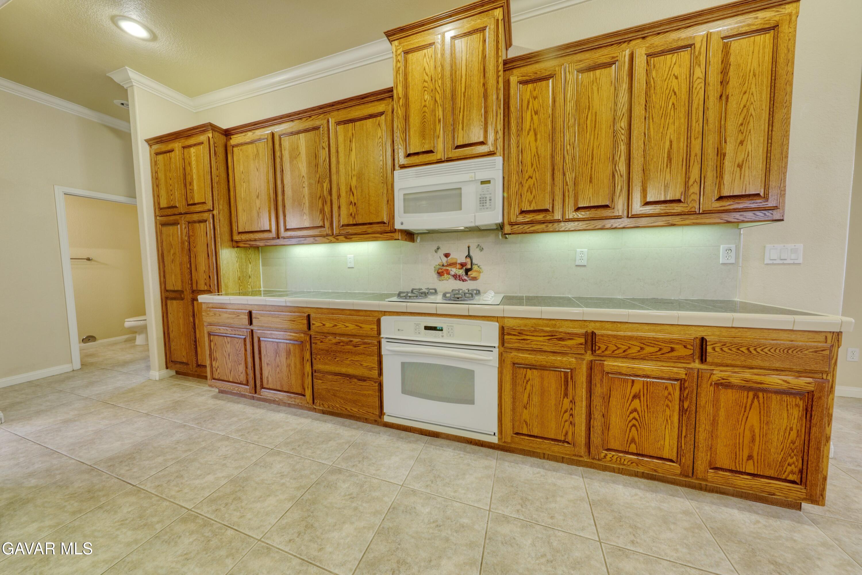 23780 Coyote Court Tehachapi, CA 93561 - Photo 20 of 48 a kitchen with stainless steel appliances granite countertop a sink and cabinets