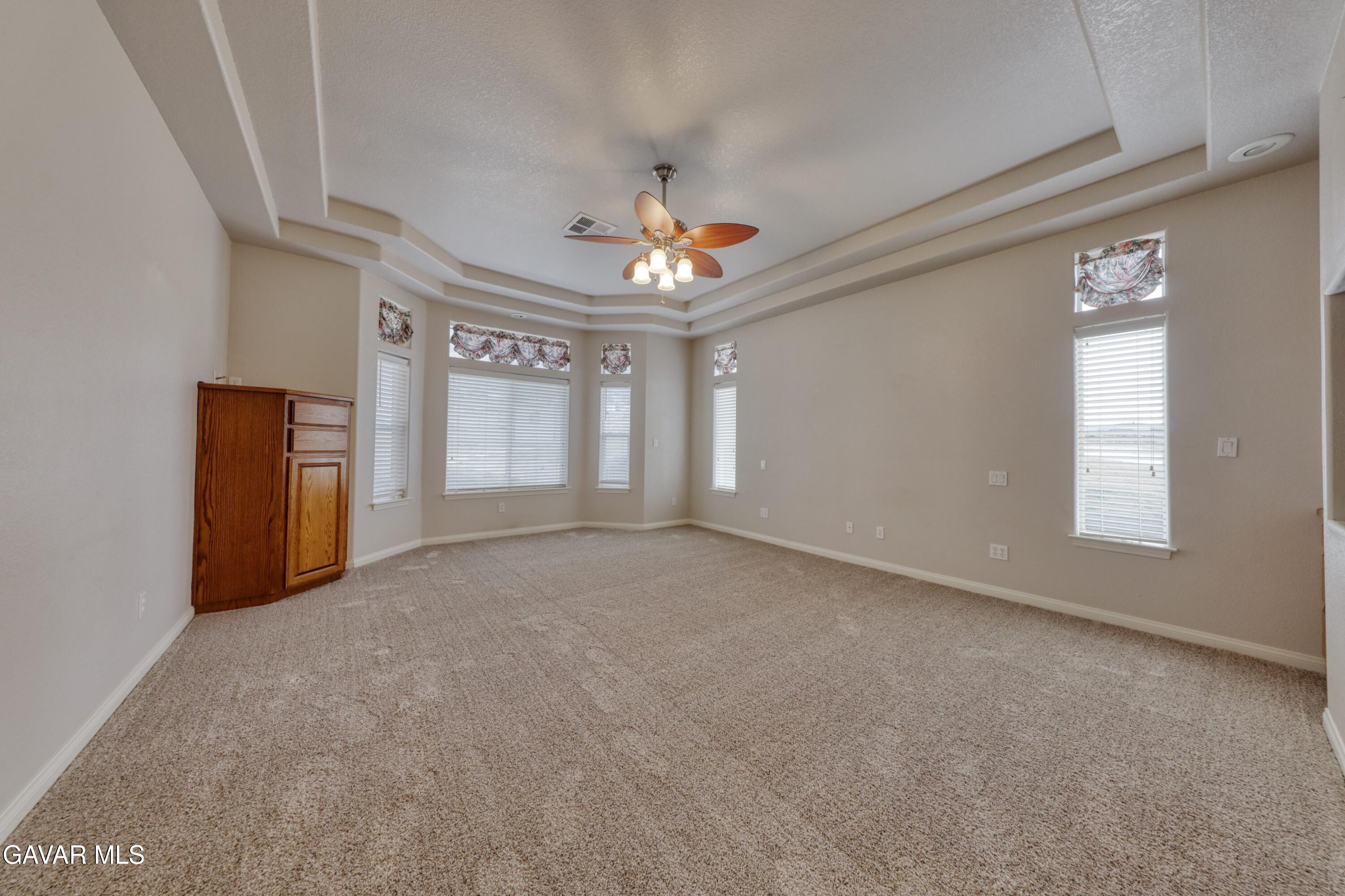 23780 Coyote Court Tehachapi, CA 93561 - Photo 24 of 48 an empty room with chandelier fan and windows
