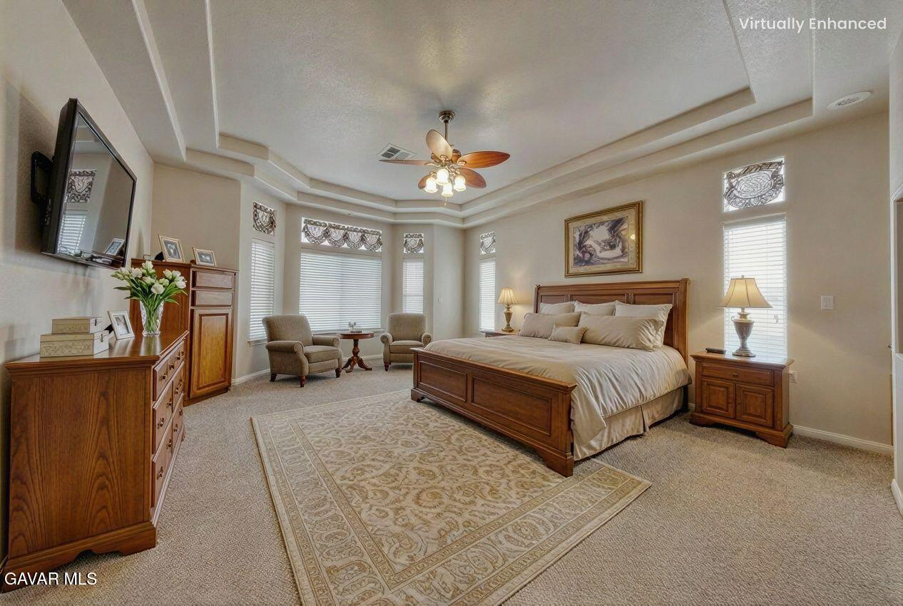 23780 Coyote Court Tehachapi, CA 93561 - Photo 25 of 48 a spacious bedroom with a bed a couch and a chandelier
