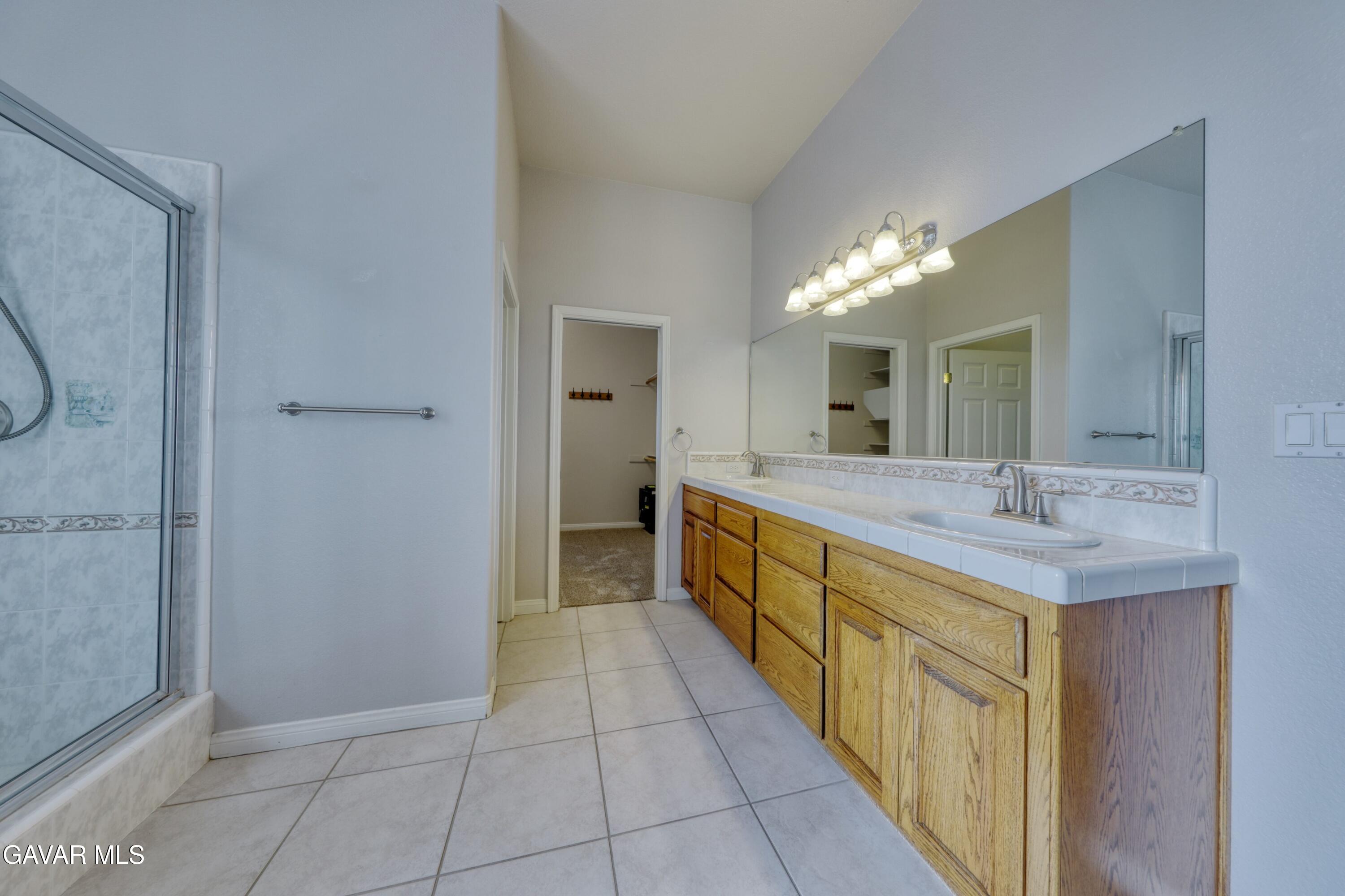 23780 Coyote Court Tehachapi, CA 93561 - Photo 27 of 48 a spacious bathroom with a double vanity sink and a mirror