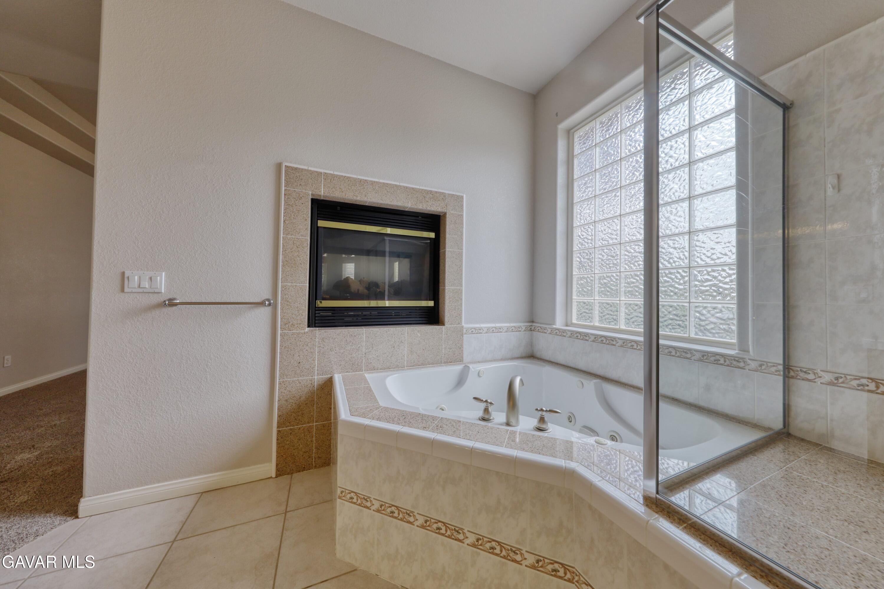 23780 Coyote Court Tehachapi, CA 93561 - Photo 30 of 48 a spacious bathroom with a bathtub and next to a window