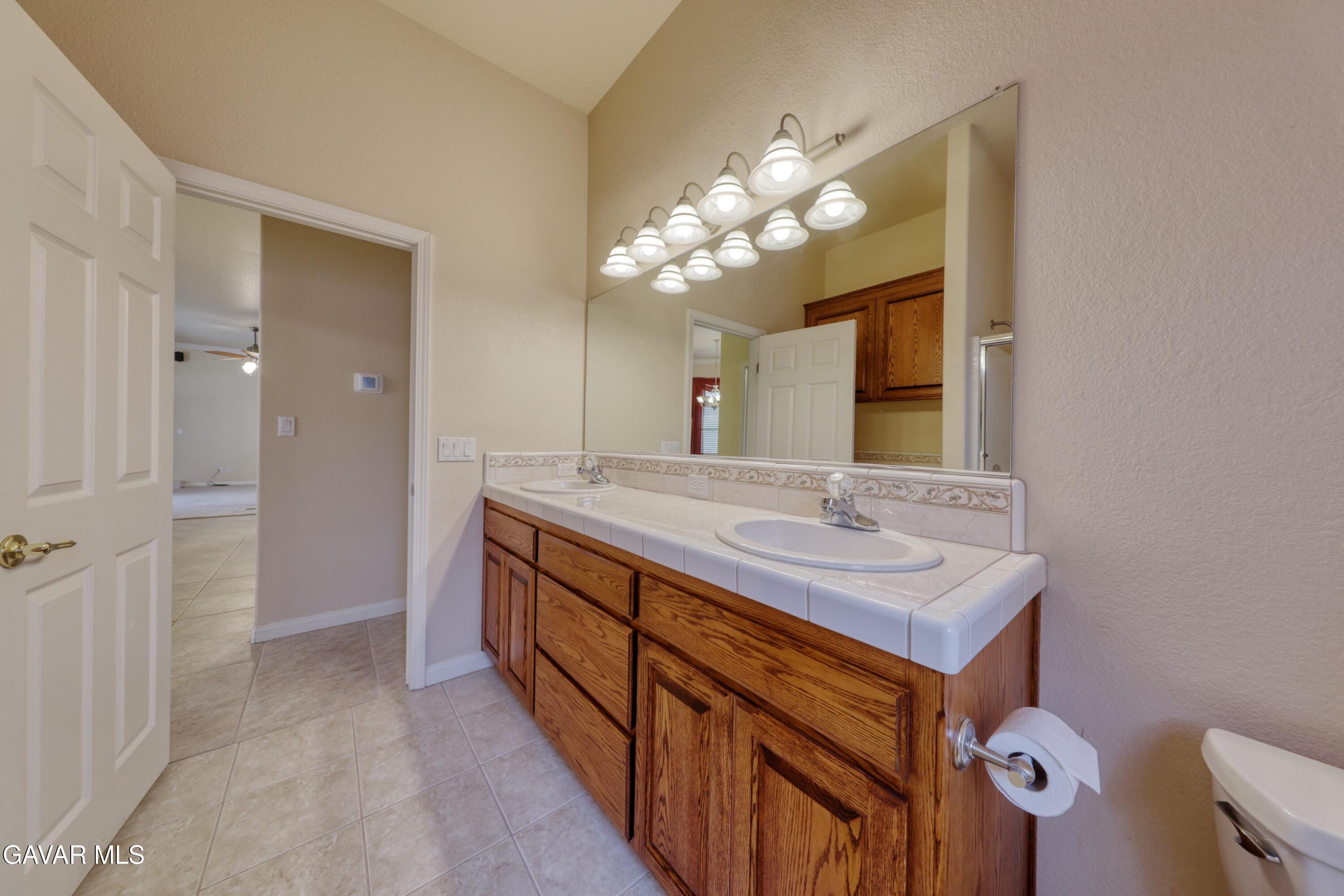 23780 Coyote Court Tehachapi, CA 93561 - Photo 37 of 48 a bathroom with a double vanity sink and a mirror