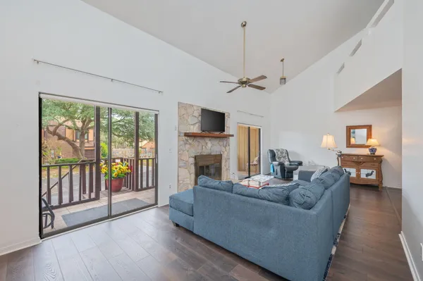 a living room with furniture a fireplace and a floor to ceiling window
