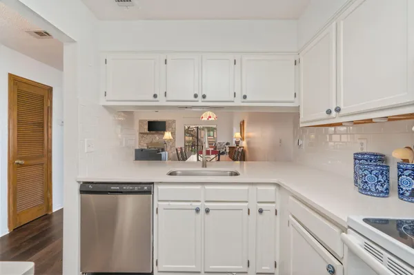 a kitchen with white cabinets and sink