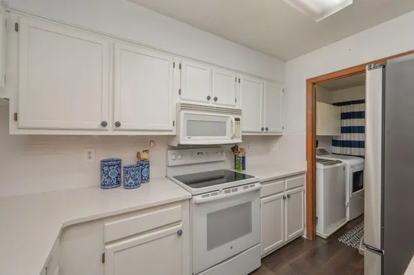 a kitchen with cabinets appliances and a wooden floor