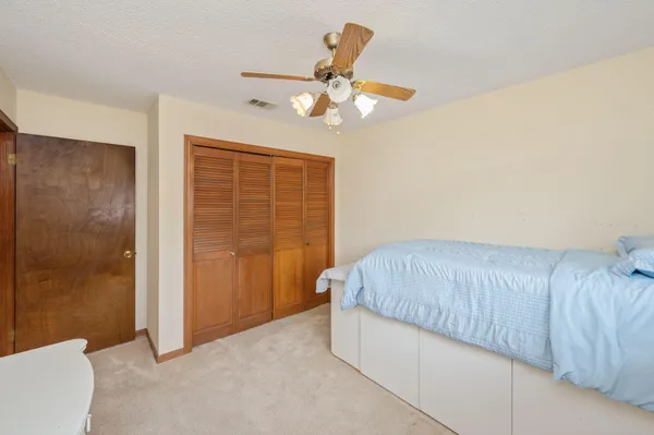 a living room with a bed and a ceiling fan