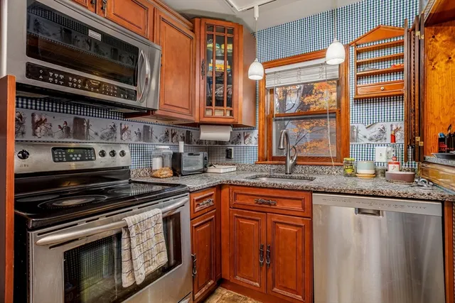 a kitchen with stainless steel appliances granite countertop a stove and cabinets