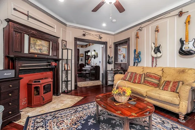 a living room with furniture a flat screen tv and a refrigerator