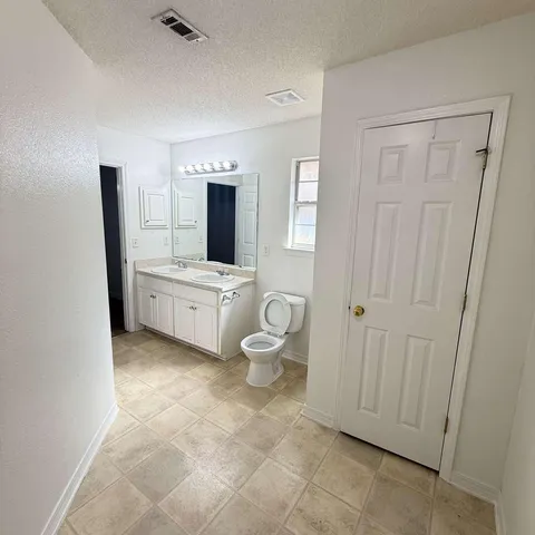 a spacious bathroom with a double vanity sink and a mirror