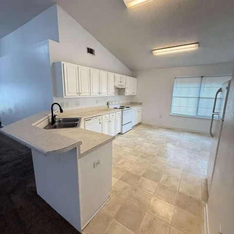 a kitchen with a sink a stove and cabinets