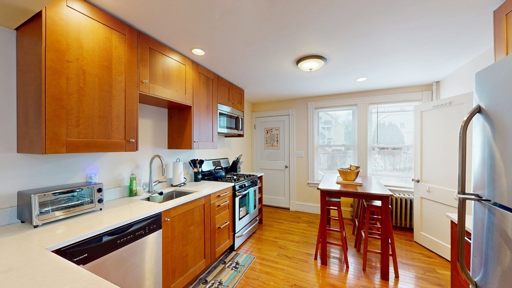 29 Montgomery Street, Unit 2 Cambridge, MA 02140 - Photo 2 of 8 a kitchen with stainless steel appliances a sink stove and cabinets