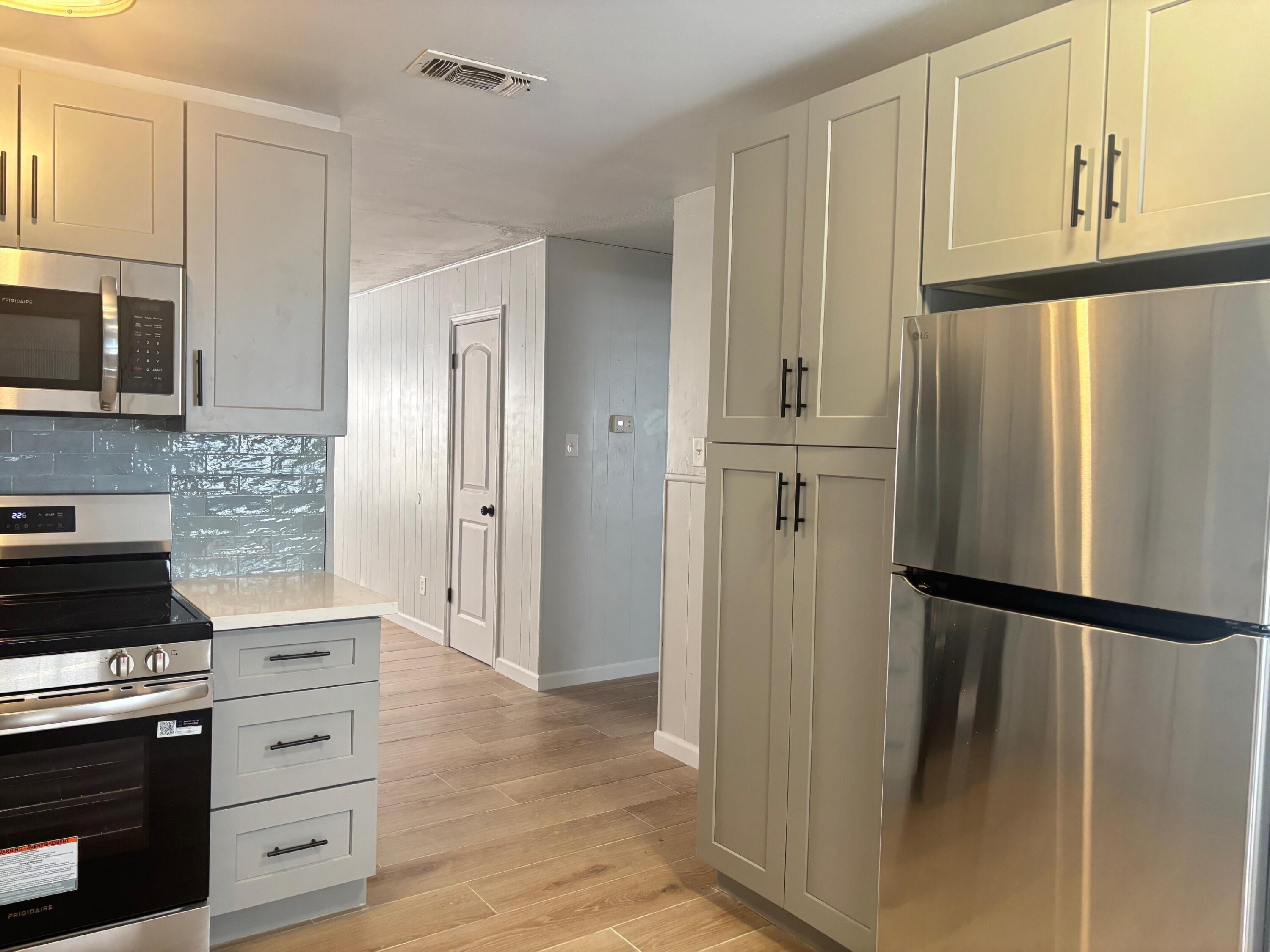 2409 45th Street, Unit 1 Lubbock, TX 79412 - Photo 4 of 11 a kitchen with white cabinets and refrigerator