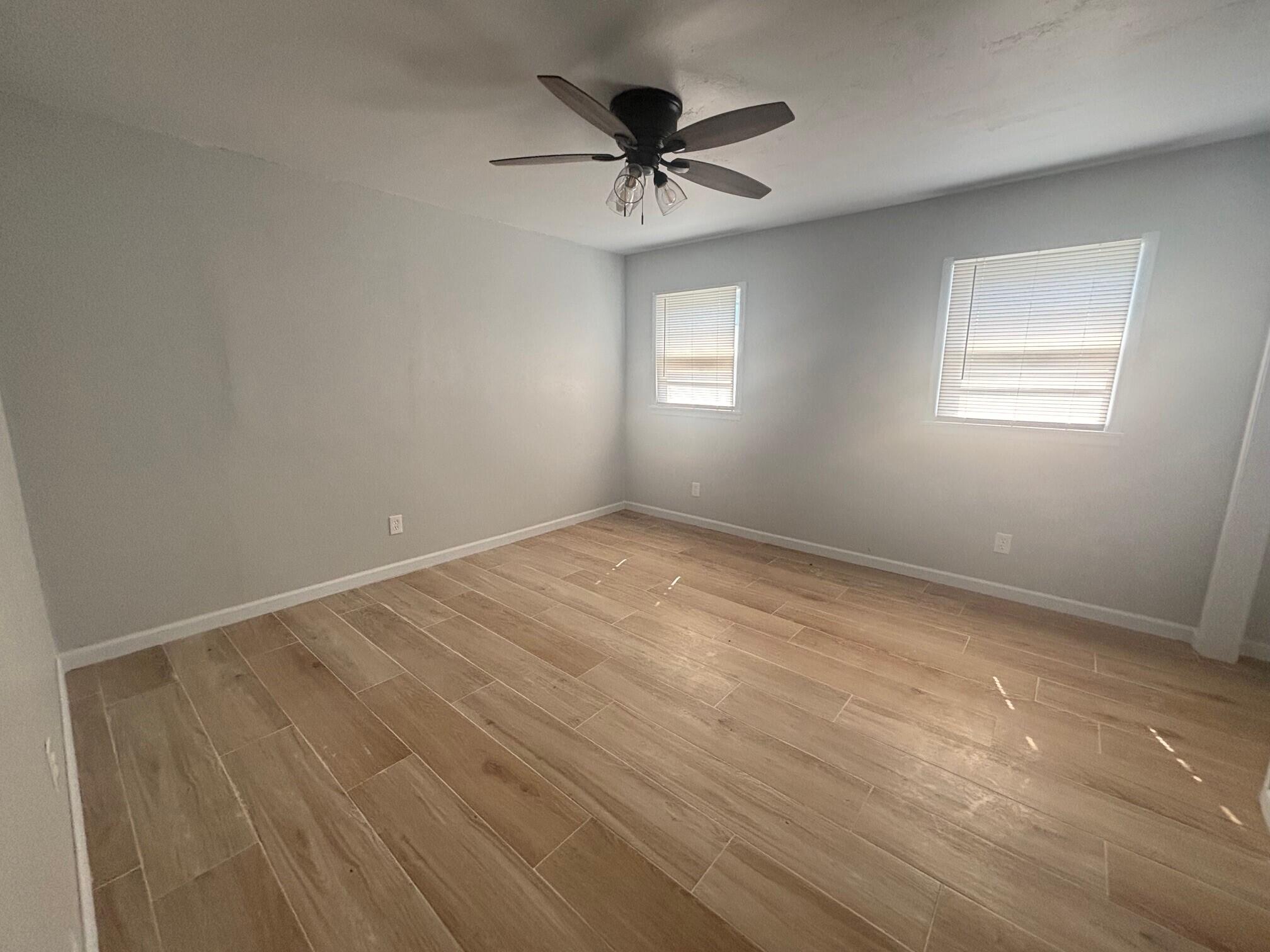 2409 45th Street, Unit 1 Lubbock, TX 79412 - Photo 6 of 11 an empty room with a window and a ceiling fan