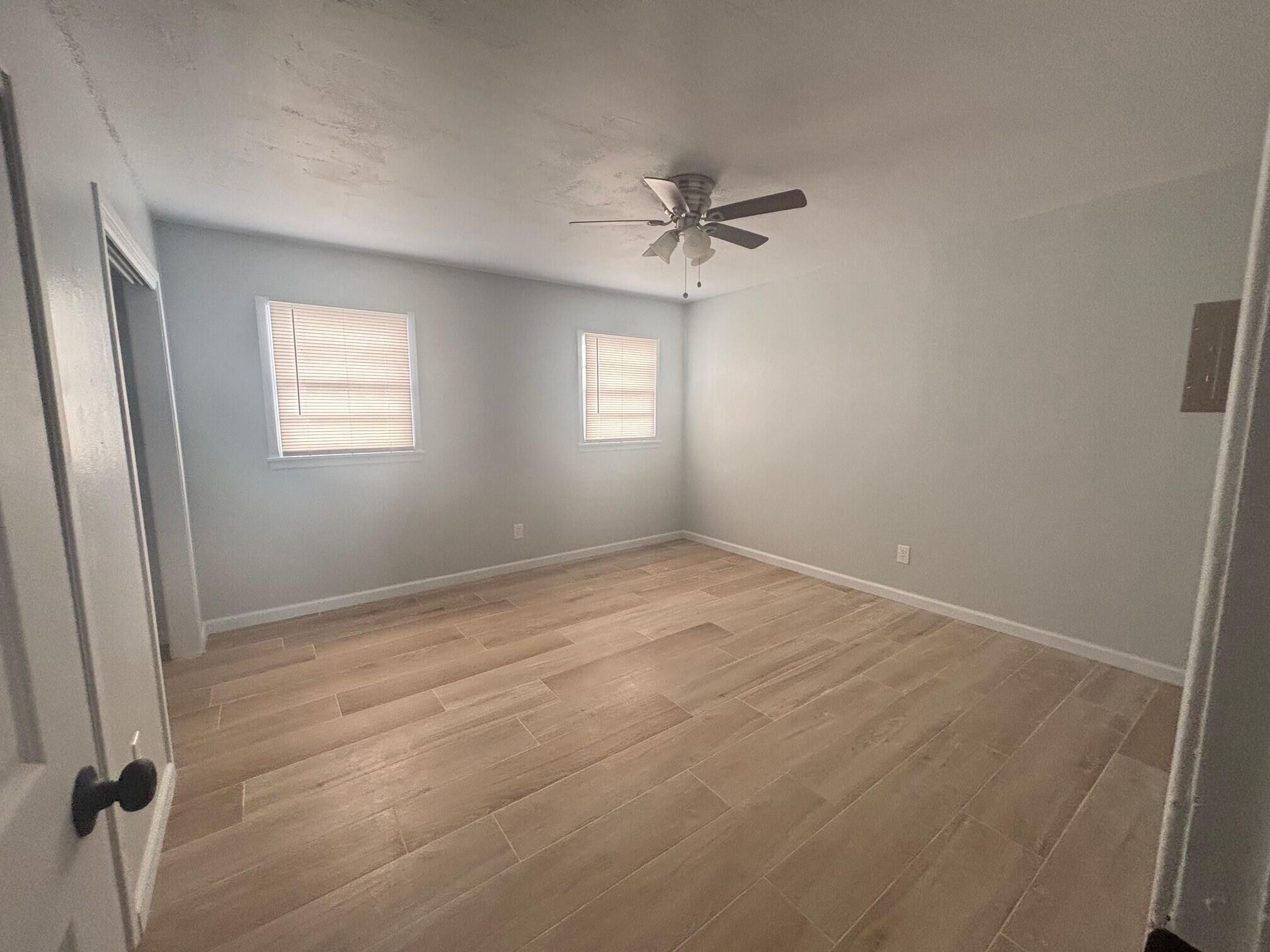 2409 45th Street, Unit 1 Lubbock, TX 79412 - Photo 7 of 11 wooden floor in an empty room with a window