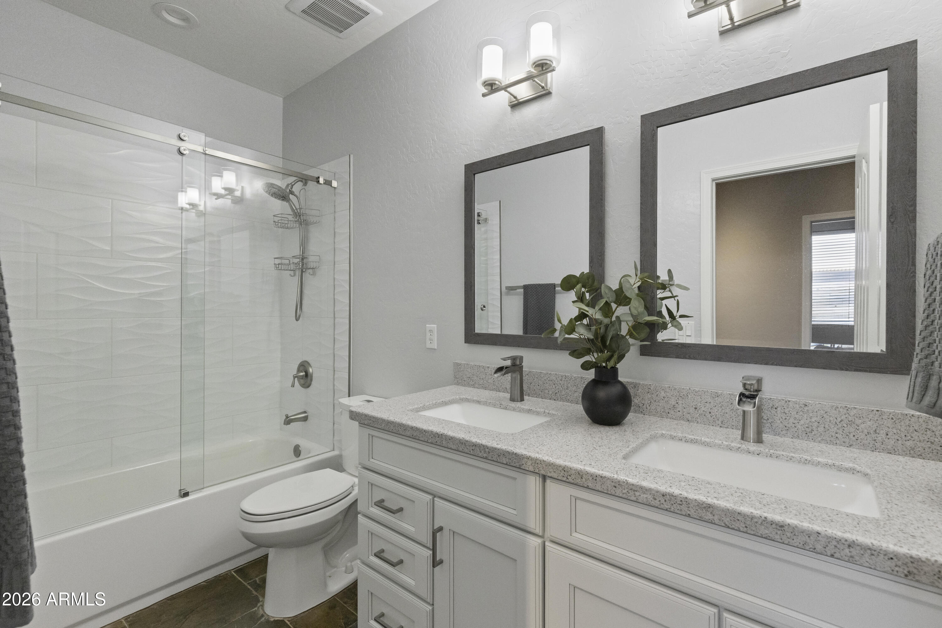 2519 East Rawhide Street Gilbert, AZ 85296 - Photo 12 of 35 a bathroom with a granite countertop sink a toilet a mirror a bathtub and shower