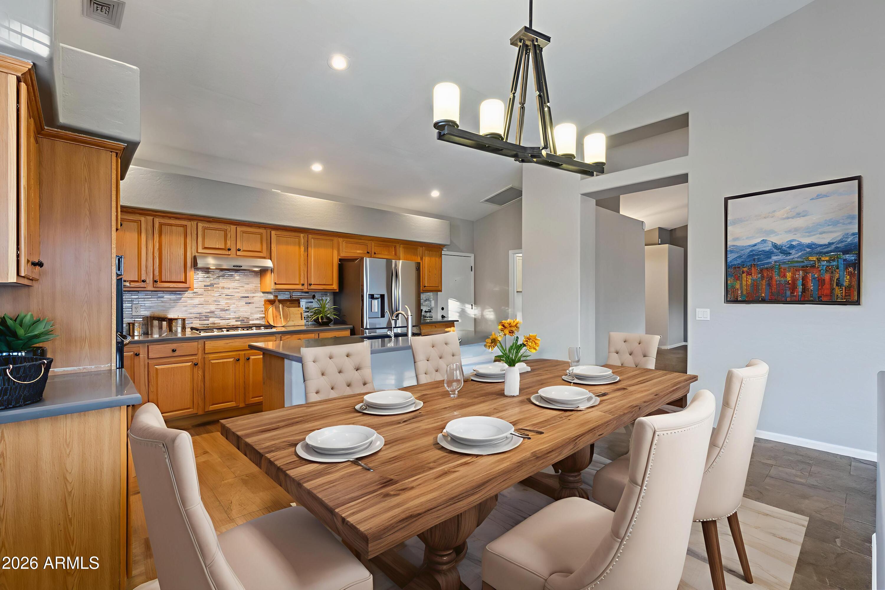 2519 East Rawhide Street Gilbert, AZ 85296 - Photo 4 of 35 a view of a dining room with furniture a chandelier and wooden floor