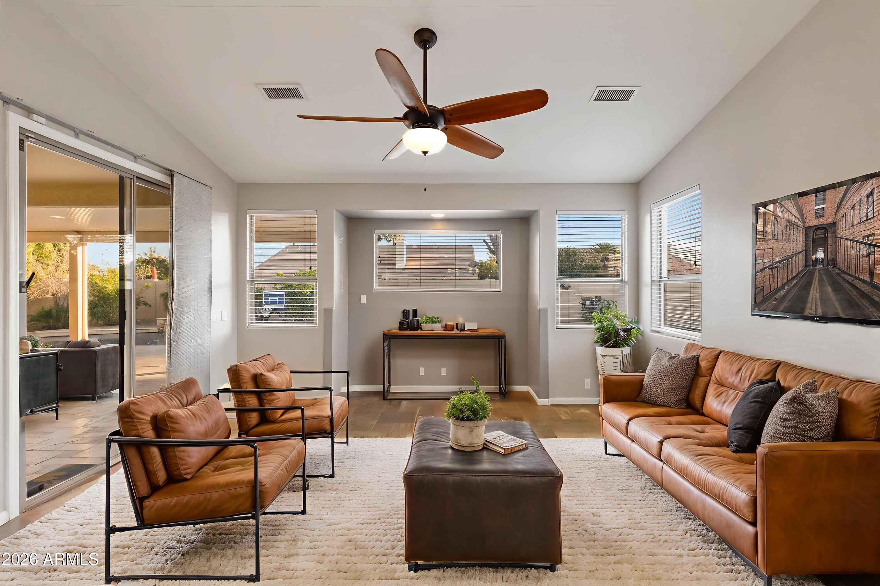2519 East Rawhide Street Gilbert, AZ 85296 - Photo 5 of 35 a living room with furniture ceiling fan and a large window