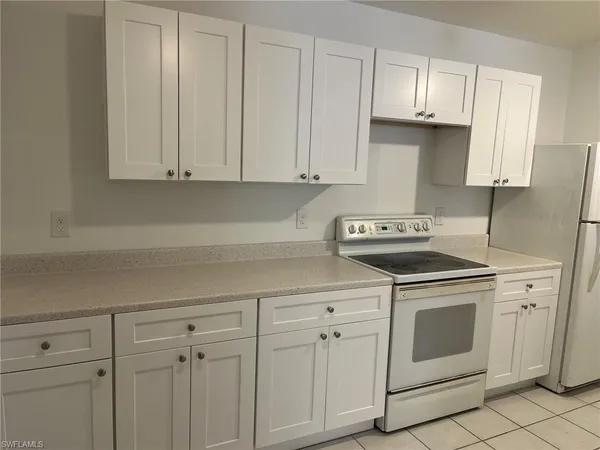 a kitchen with white cabinets and white appliances