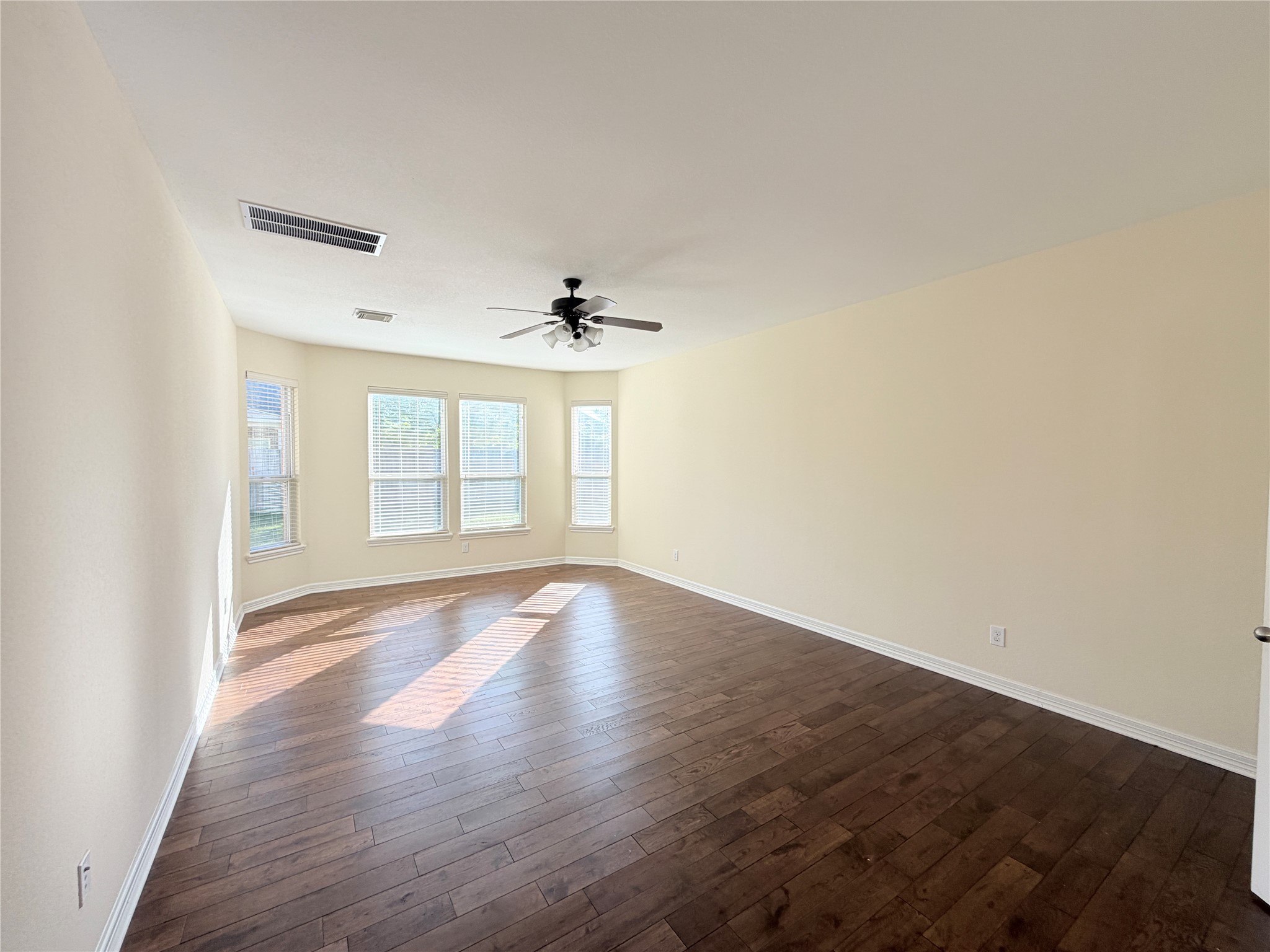 28015 Silverstream Court Fulshear, TX 77441 - Photo 13 of 33 a view of an empty room with wooden floor and a window