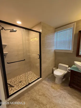 a spacious bathroom with a toilet a sink and a mirror