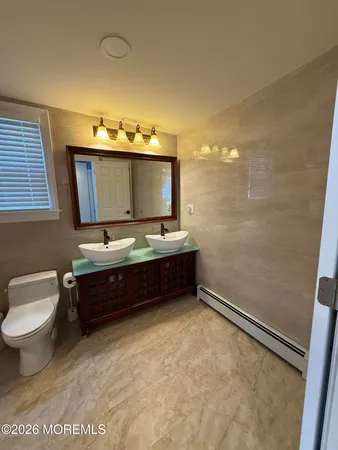 a spacious bathroom with a toilet a sink and a mirror