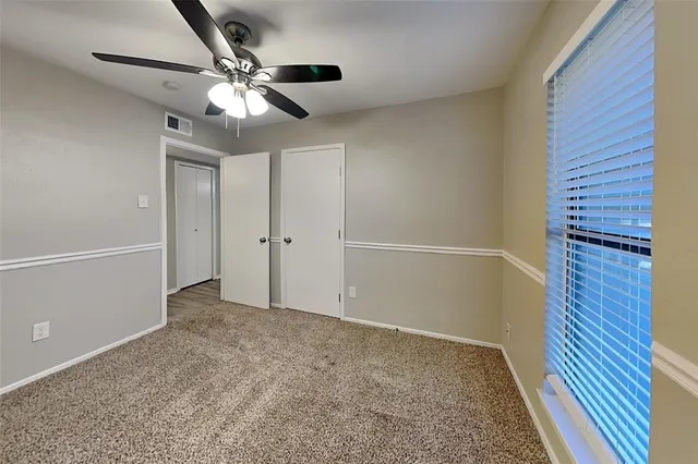an empty room with closet and fan
