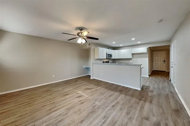 a view of a kitchen with a sink a refrigerator and wooden floor