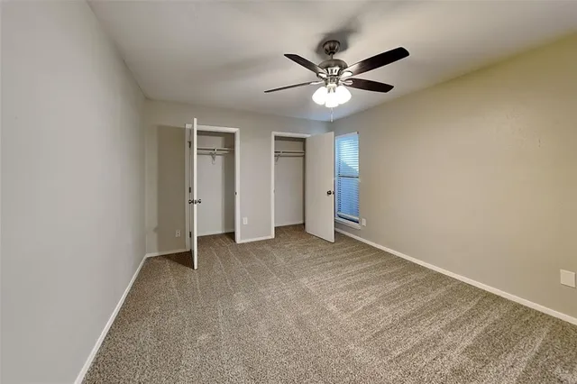 an empty room with a large mirror and a ceiling fan